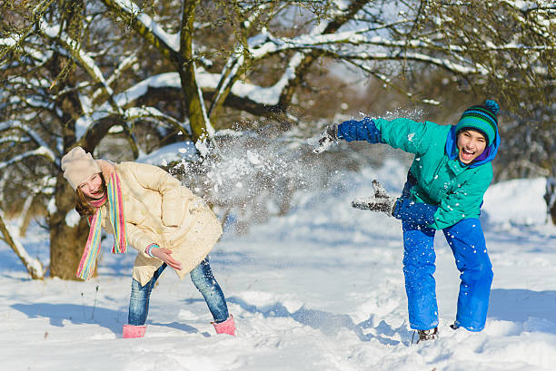 Children play in snowy forest. Toddler kids outdoors in winter stock photo