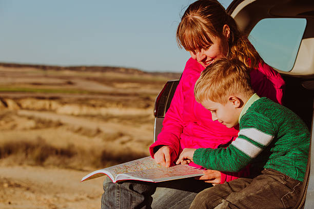 istock mother and son looking at map while travel by car 637740342