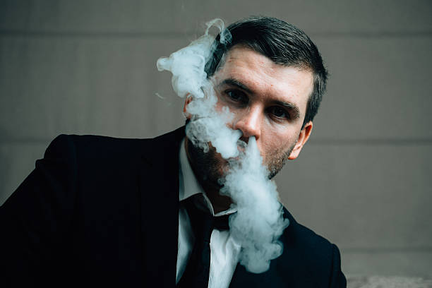 istock businessman blows smoke from his nose 637745320