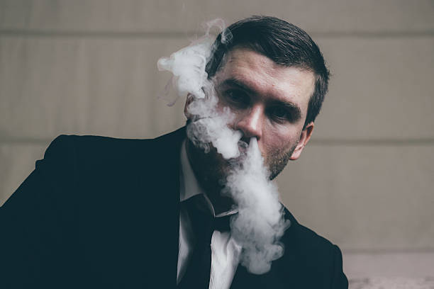 istock businessman blows smoke from his nose 637745542