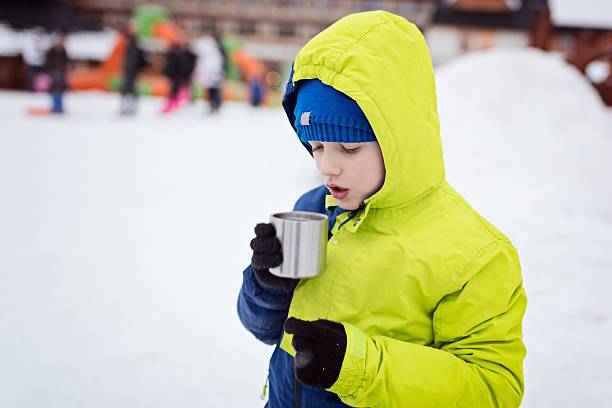 istock Child drinking hot tea from the metal mug. 637748260