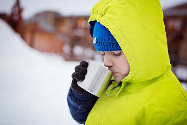 istock Child drinking hot tea from the metal mug. 637748334