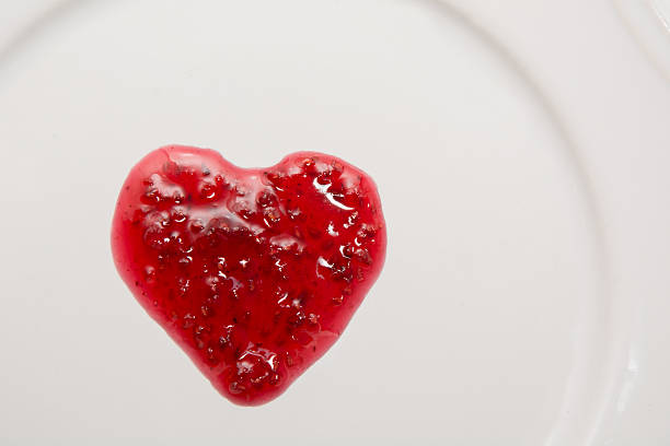 raspberries jam in shape of heart isolated on white background. - jellied cranberries fotos imagens e fotografias de stock