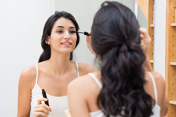 Woman applying mascara Woman applying black mascara on eyelashes with makeup brush. Young beautiful woman applying mascara makeup on eyes at bathroom. Beautiful brunette girl applying makeup on eyes in the morning time. mascara wands stock pictures, royalty-free photos & images
