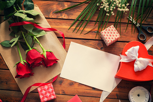 Romantic bouquet of red roses,blank greeting card and hearts shaped gift box for Valentine's Day