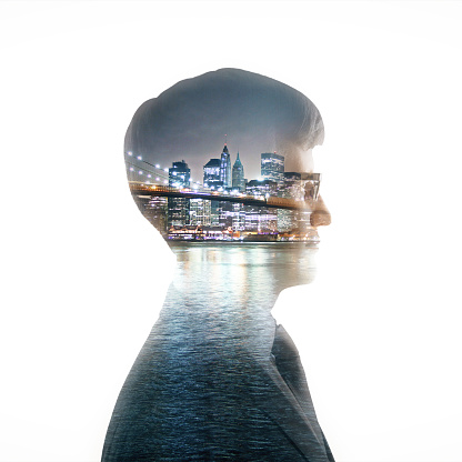 Side portrait of young caucasian businessman on modern night city background. Double exposure. Research concept