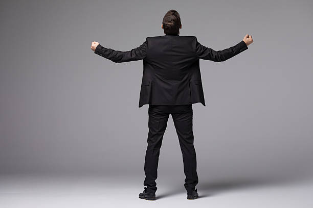 istock Young businessman in suit raised hands back side isolated 637761172