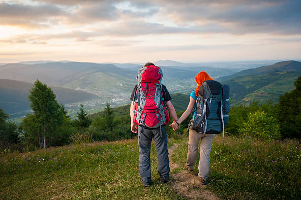 istock Back view couple tourists walking down from the mountains 637762290