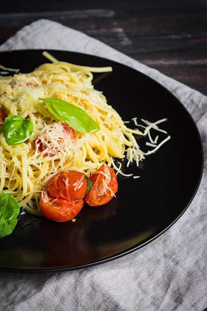 istock Pasta with tomatoes and basil on the dark background 637769270