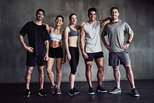 Portrait of a group of fit young people standing together at the gym
