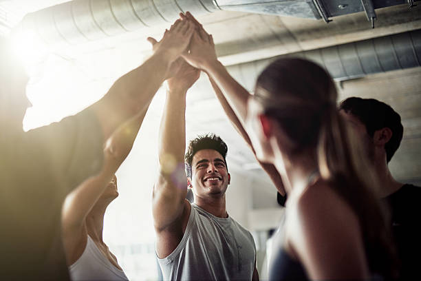 Striving for fitness excellence Shot of a group of fit young people giving each other a high five at the gym community health center stock pictures, royalty-free photos & images