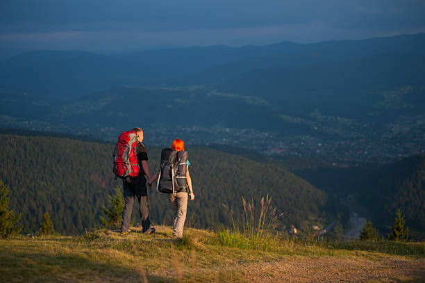 istock Family hikers with backpacks holding hands and walking along 637772466