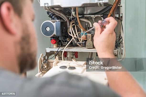 Technician Repairing Gas Furnace Stock Photo - Download Image Now - Furnace, Boiler, Repairing