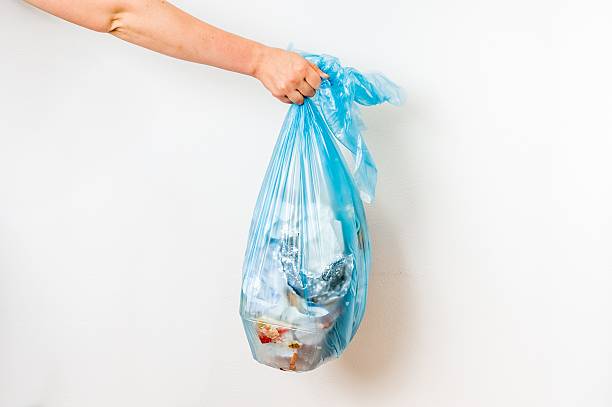 istock Female hand holding blue garbage bag 637773098