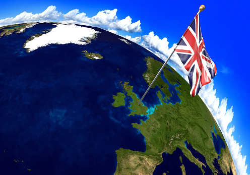 3D render of the national flag of the United Kingdom over the geographic location of the country on a world map. Parts of this image furnished by NASA.