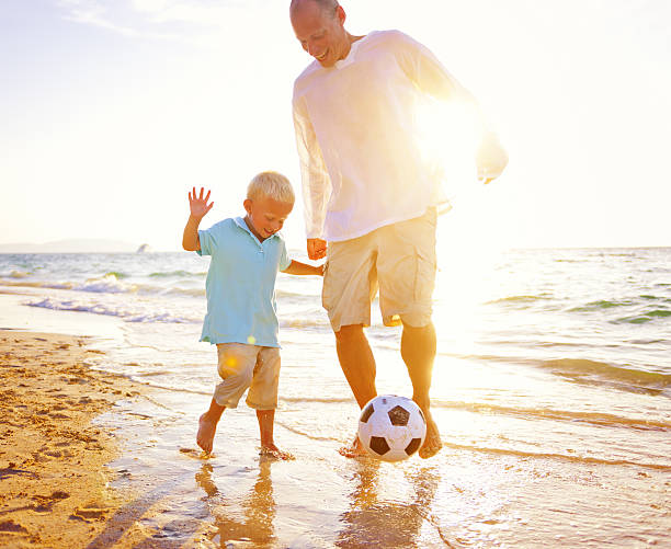 istock Father Son Playing Soccer Beach Summer Concept 637775504