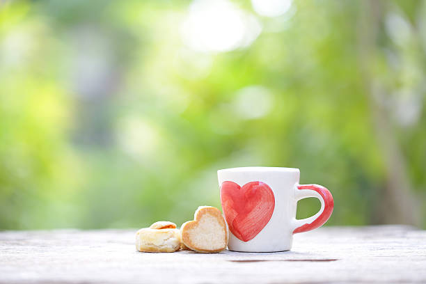 istock white cup whit heart pattern on wooden table 637775958