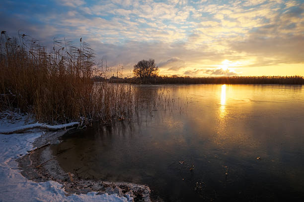 istock Winter landscape with sunset sky and frozen river. Daybreak 637776438