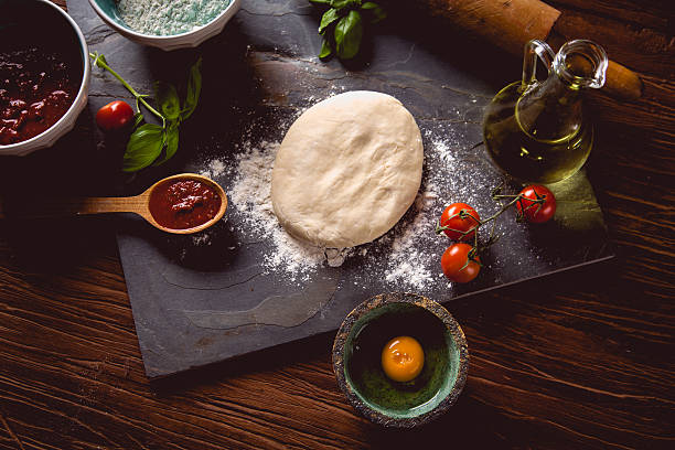 istock Dough with flour on wooden table, preparing homemade pizza 637781324