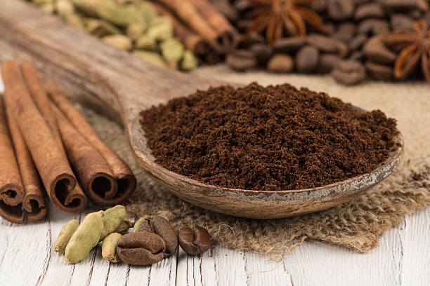 istock Ground coffee in a wooden spoon on white wooden table. 637781954