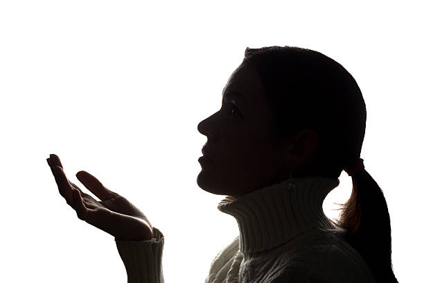 istock Young woman looking up with hope and request - silhouette 637783178