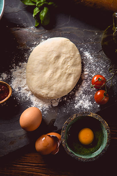 istock Dough with flour on wooden table, preparing homemade pizza 637783338