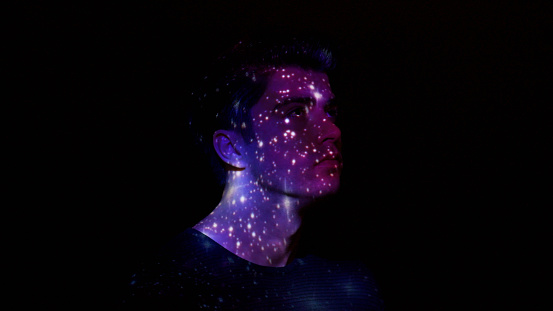 Projection of stars on a man's face.