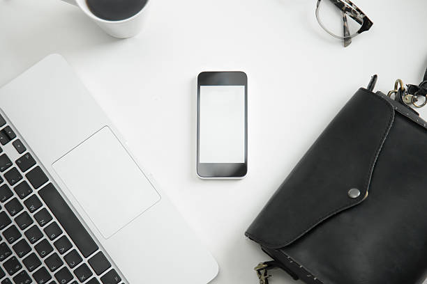 istock White office desk with keyboard, glasses, mobile phone, handbag 637786104