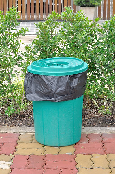 istock Plastic Green bucket with black garbage bag on bricks. 637789376