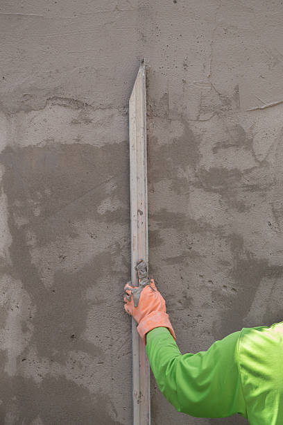 istock hand using trowel to finish wet concrete wall 637790772