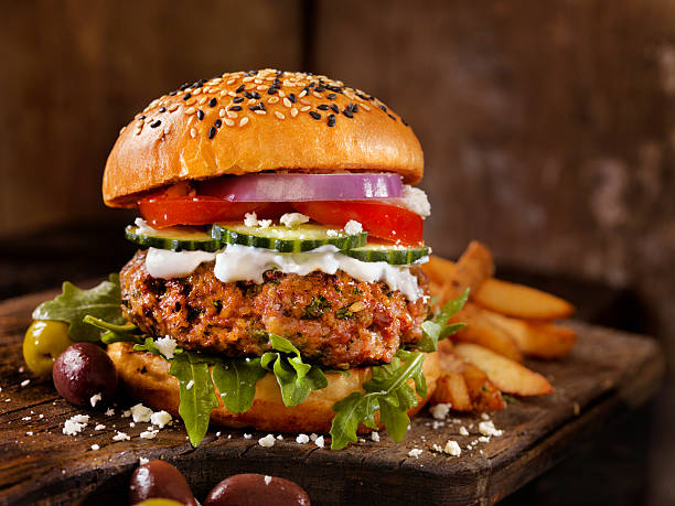 100% Lamb -Greek Burger 100% Lamb -Greek Burger with Arugula, Cucumber, Tomatoes, Feta and Tzatziki Sauce - Photographed on Hasselblad H3D2-39mb Camera greek culture photos stock pictures, royalty-free photos & images