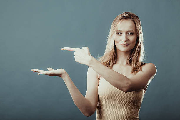 istock Young woman holding open palm showing copy space 637790890