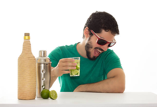 バーテーブルで楽しんで、カクテルを飲む男 - cocktail bar caipirinha drink ストックフォトと画像