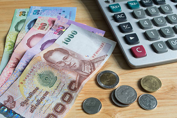 istock Thai banknotes and coins with calculator 637793774