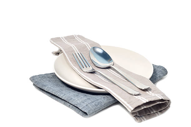 istock Gray napkin with stainless spoon and fork on white plate. 637794004