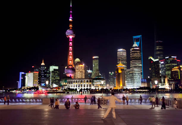 Shanghai, China - September 1st 2024:  tourists and local people take take photos and souvenirs by the bund at night. The Bund is located in the Huangpu District which is downtown Shanghai