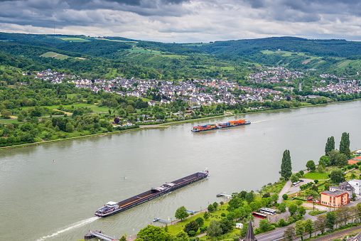 Brey, Germany - May 23, 2016: Container and cargo ship on the Rhine River, Rhine Valley, UNESCO World Heritage Site, Germany. Brey and Rhens in background.