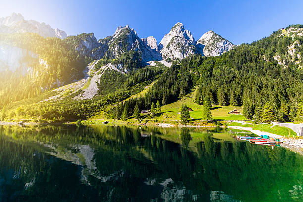 scenario estivo colorato con limpido lago di montagna gosausee e barche - clear sky panoramic grass scenics foto e immagini stock