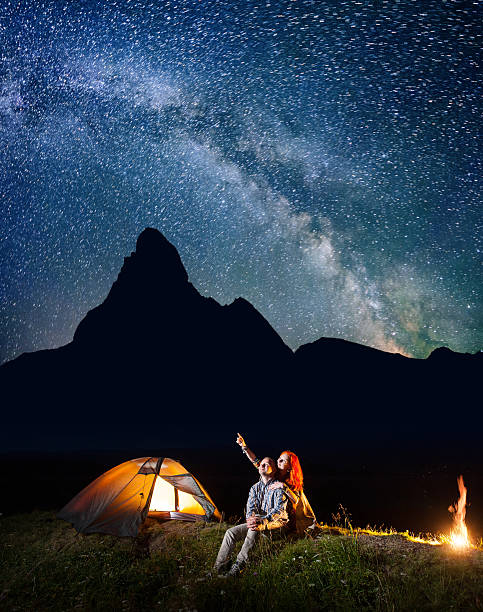 istock Couple hikers looking at the shines starry sky at night 637794512