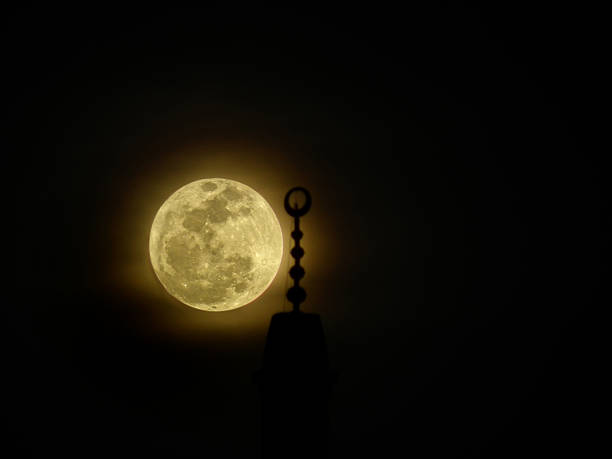 Moon behind mosque minaret, Islamic background