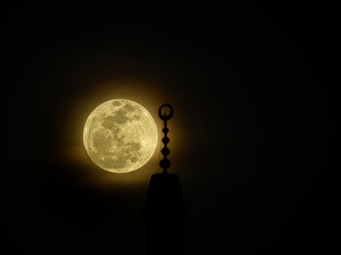 Moon behind mosque minaret, Islamic background