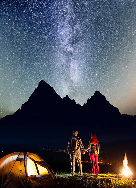 istock Man and woman holding hands, standing near camp 637795194