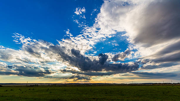 istock sunset with dramatic sky over agricultural green field 637795436