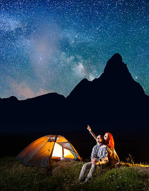 istock Girl and guy looking at the starry sky at night 637797604