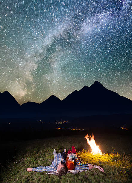 istock Tourists lying near the campfire under incredibly beautiful starry sky 637797962