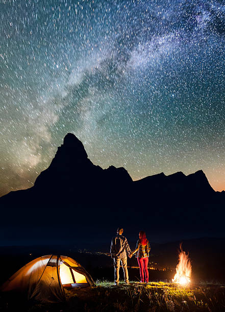 istock Romantic pair hikers holding hands, standing near camping 637798150