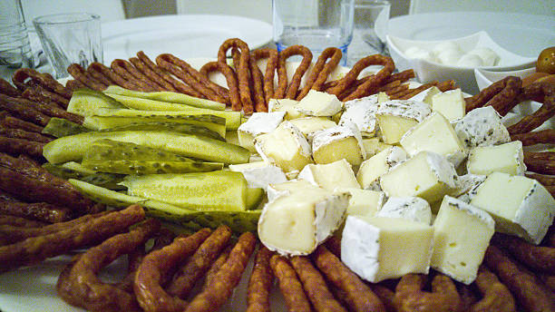 Plate with pickles, hermelin cheese and kabanos - sausage sticks Big platter of sliced pickles, hermelin cheese and kabanos - sausage sticks hermelin mustela erminea stoat stock pictures, royalty-free photos & images
