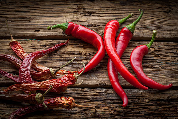 istock Red hot chili peppers on wooden table 637800584