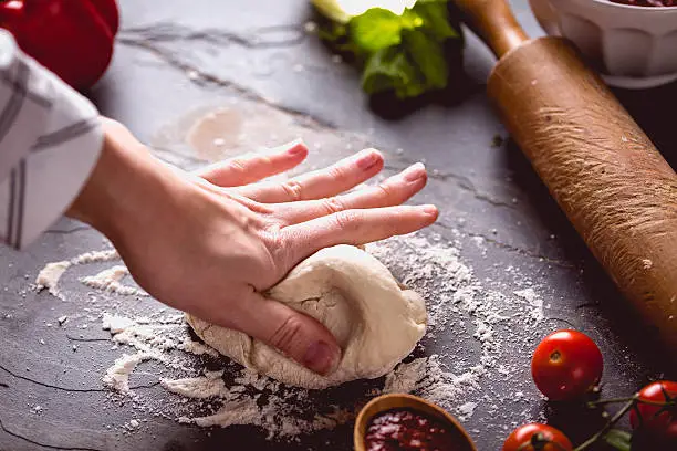 Photo of Young girl's hand knead the dough