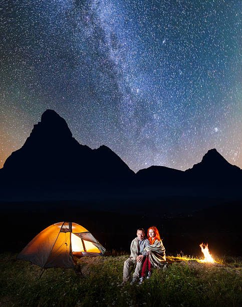 istock Young couple backpackers sitting together under starry sky 637801446